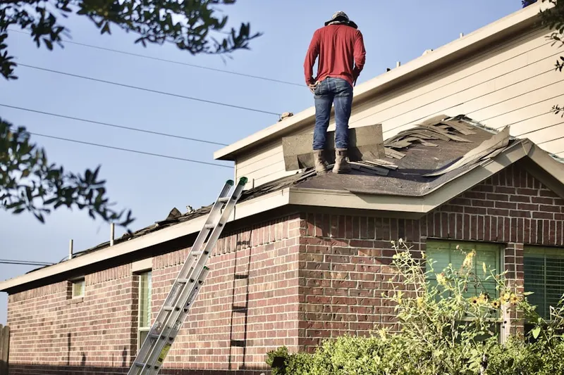Professional roofer working on a residential roof in Goddard
